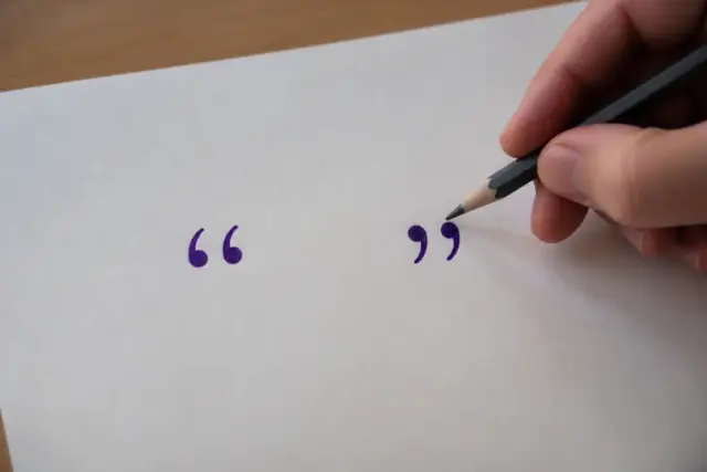 Un crayon et une feuille portant des guillemets français tracés à l’encre violette