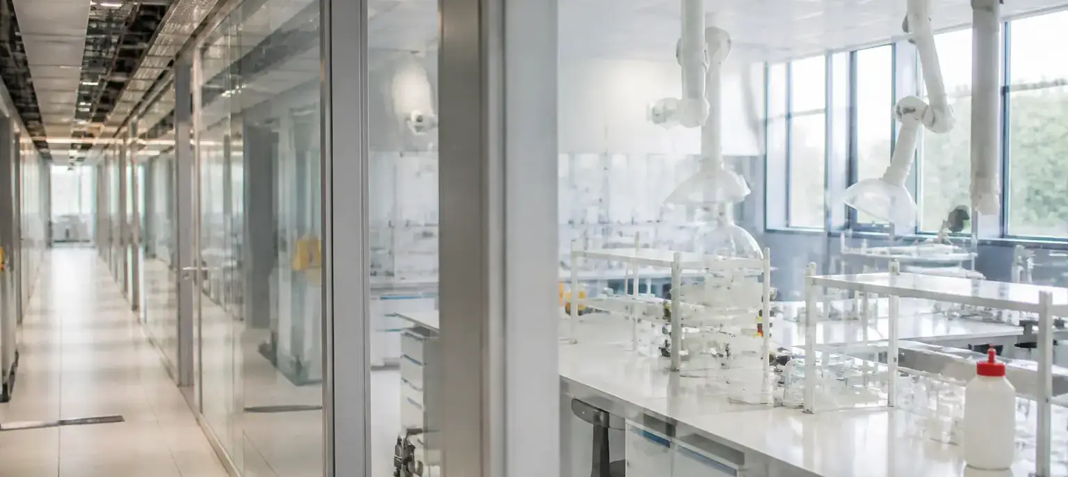 Un couloir d’institut universitaire avec des salles de travaux pratiques aux portes vitrées