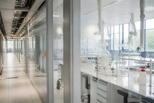 Un couloir d’institut universitaire avec des salles de travaux pratiques aux portes vitrées