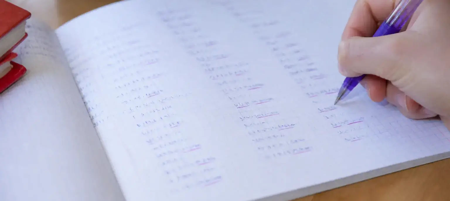 Un tableau de conjugaison manuscrit où les terminaisons sont soulignées d’un trait d’encre violette
