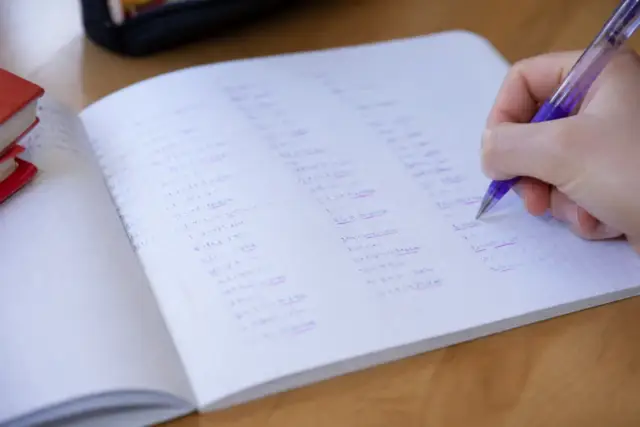 Un tableau de conjugaison manuscrit où les terminaisons sont soulignées d’un trait d’encre violette